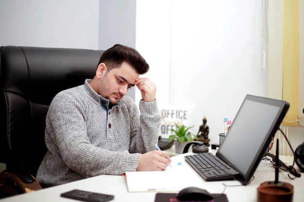 A young businessman is in stress and reading the paper.