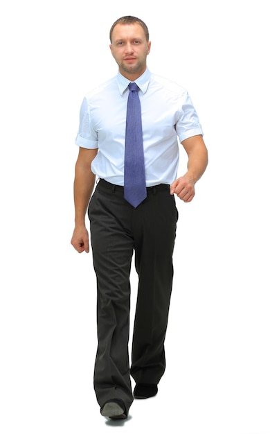 Young businessman is walking He is smiling and looking to the camera isolated over white background