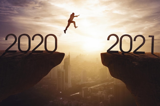 Young businessman jumps a gap from 2020 to 2021