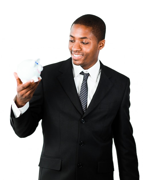 Young businessman looking at a piggy bank 