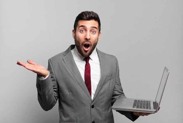 Young businessman looking surprised and shocked