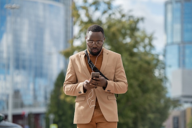 Young businessman looking through playlist in smartphone