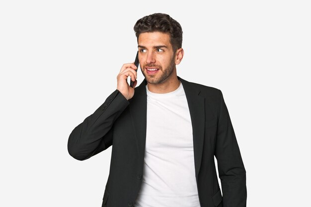 Young businessman multitasking with ease speaking confidently on his mobile phone