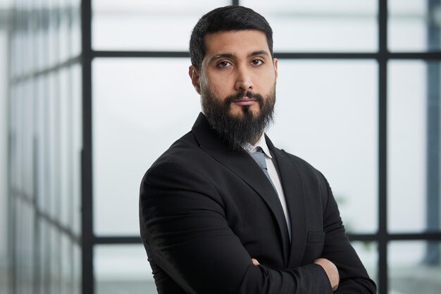 young businessman in the office with his arms crossed