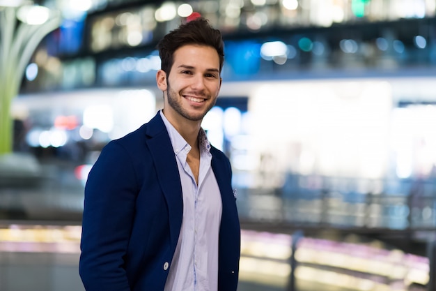 Young businessman outdoor in a modern city setting at night