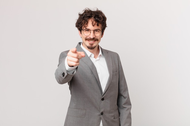 Young businessman pointing at camera choosing you