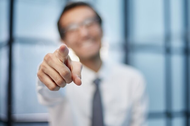 Young businessman points his finger at an object