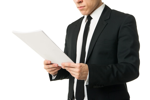 Young businessman reading papers from work isolated on white background