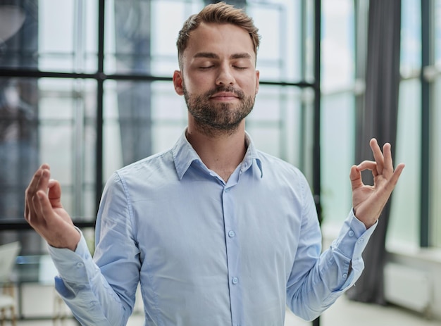 Young businessman relaxing while standing in the office