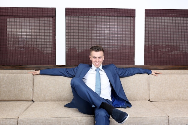 Young businessman resting on couch in office