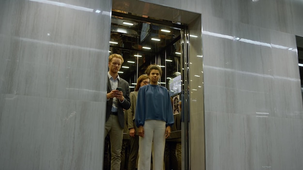 Photo young businessman rushing to office meeting business man running in office corridor multi ethnic business people standing in lift car corporate professional late for meeting elevator doors open