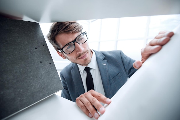 Young businessman selects a folder for documents