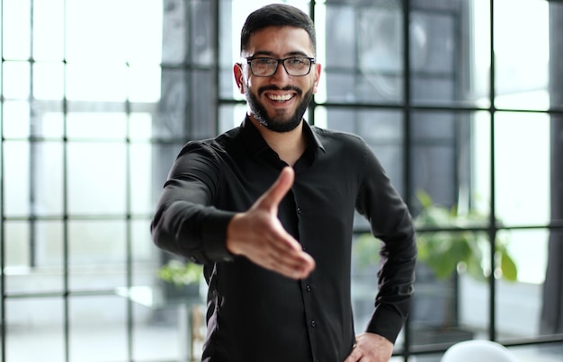 Young businessman shakes hands with a business partner