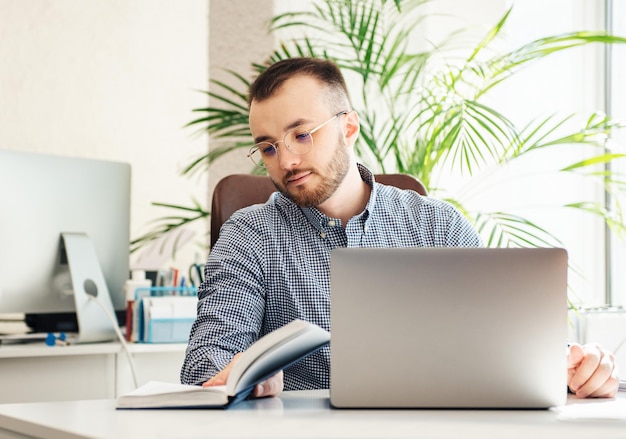 Young Businessman in shirt working on his laptop in an office