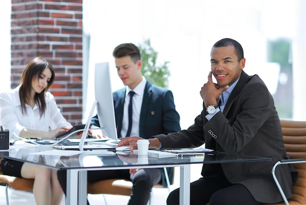 Young businessman sitting behind a Desk in a modern office