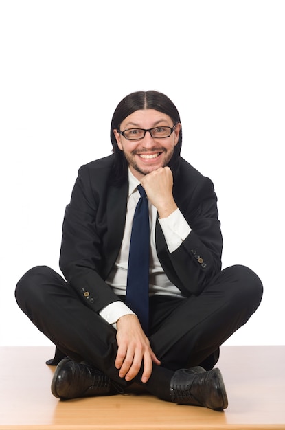 Young businessman sitting on the floor isolated on white