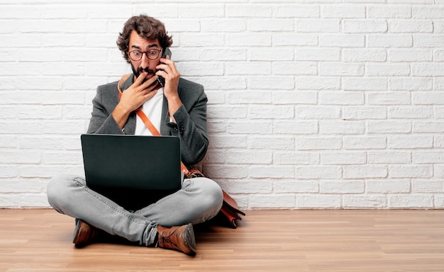 young businessman sitting on the floor with a laptop