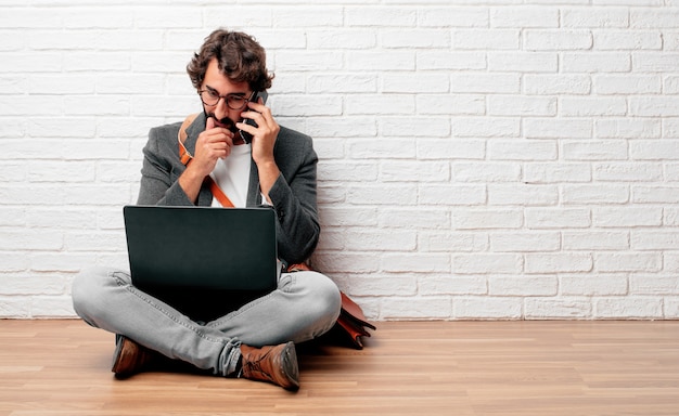 young businessman sitting on the floor with a laptop