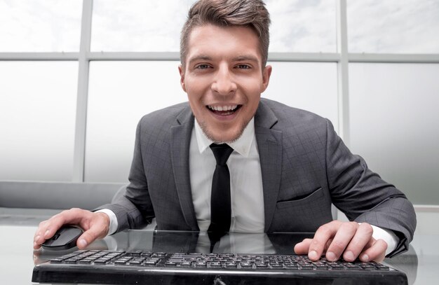 Young businessman sitting in his office looking at camera