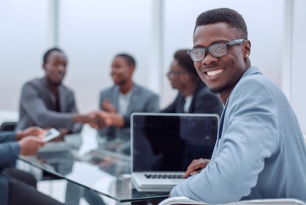 Young businessman sitting at office desk and looking at camera