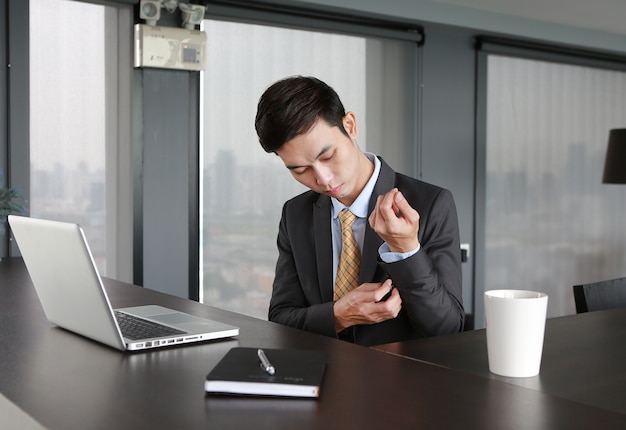 Young businessman sitting at the table and wearing suit