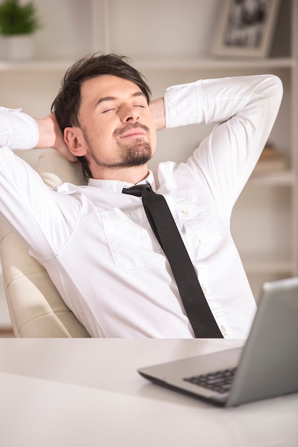 Young businessman sleep before of a laptop.