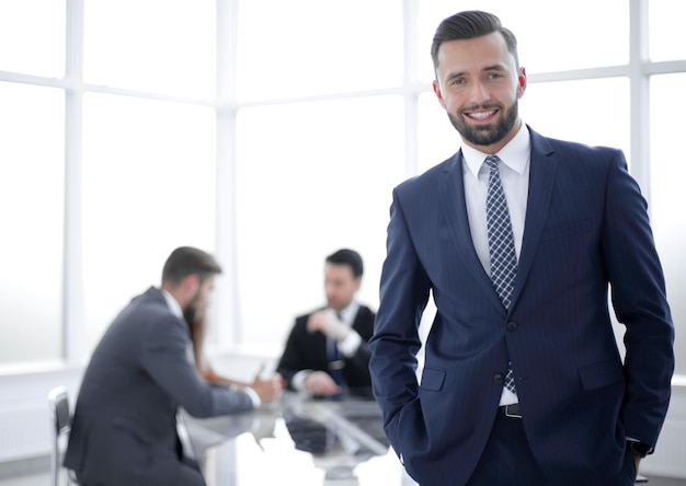 Young businessman standing in a bright officephoto with copy space