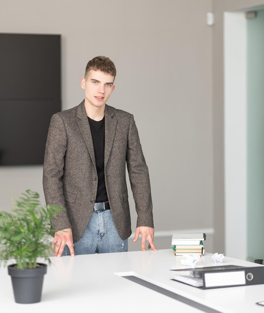Молодой бизнесмен, стоящий в современном офисе