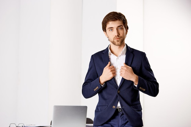 Young businessman standing near the office desk