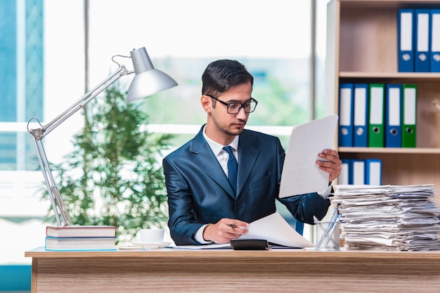 Young businessman in stress with lots of paperwork