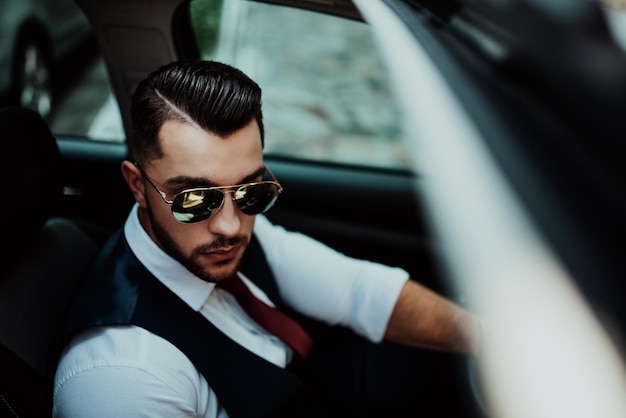 A young businessman in a suit goes to work with car