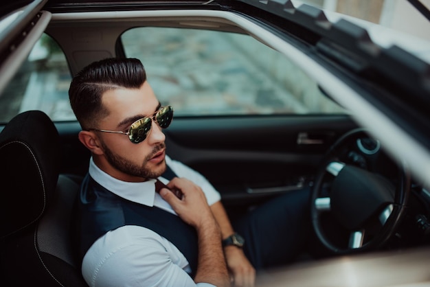 A young businessman in a suit goes to work with car