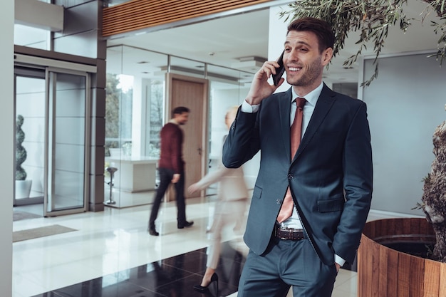 Young businessman talking on a cellphone indoors