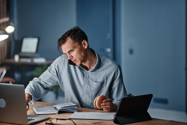 Young businessman talking on a smartphone and using a digital tablet