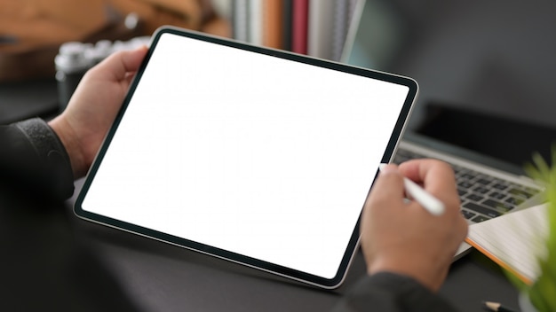 Photo young businessman using blank screen digital tablet in modern office