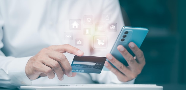 Young businessman using credit card to make financial transactions via smartphone