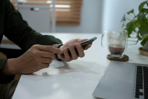 Young businessman using smart phone on white table