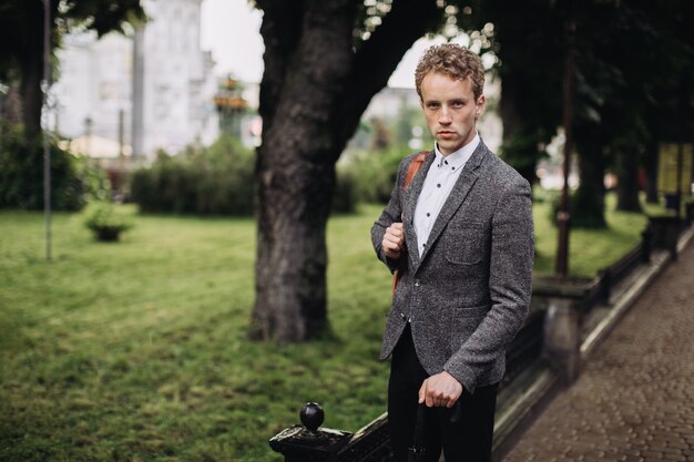 Young businessman walking down the lane in a rainy weather