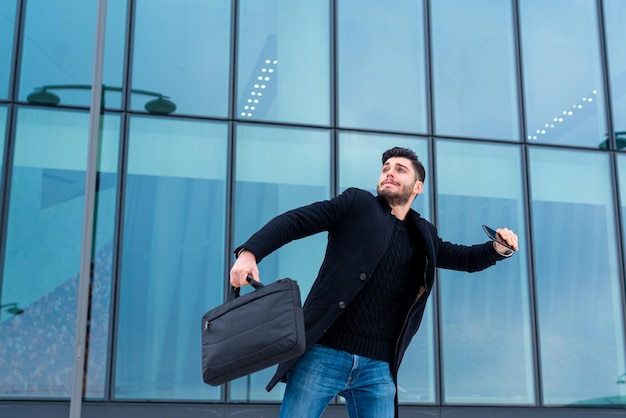 Young businessman wants to throw his cell phone in a fit of
rage caused by the loss of his financial asset concept of anger
freedom from social network applications bankruptcy of the
corporation