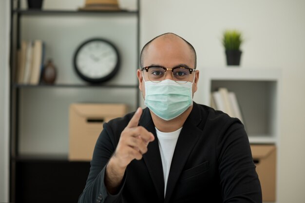 Foto giovane imprenditore che indossa la maschera protettiva in ufficio