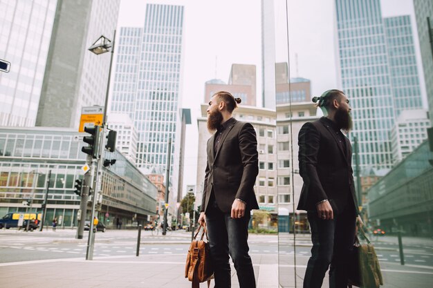 Young businessman with beard in town