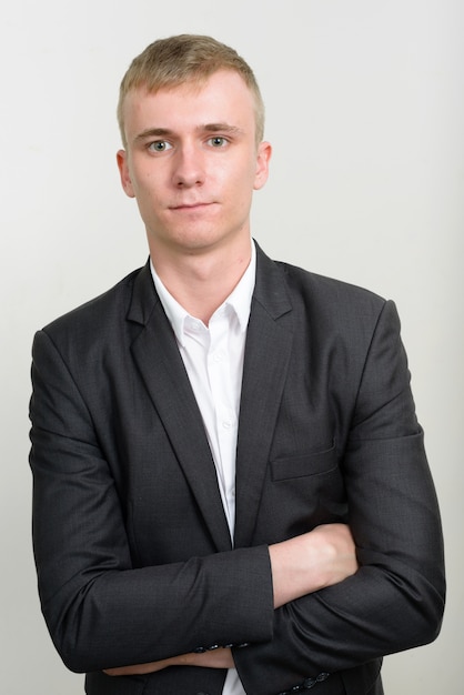 young businessman with blond hair wearing suit on white