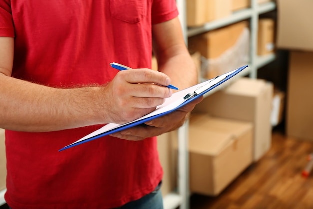 Young businessman with clipboard at warehouse