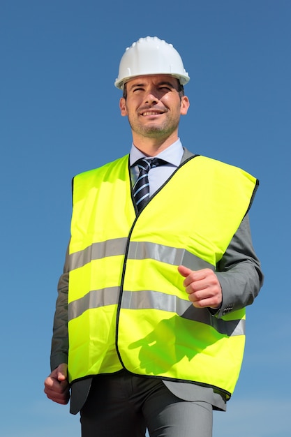 Young businessman with hardhat and blue sky