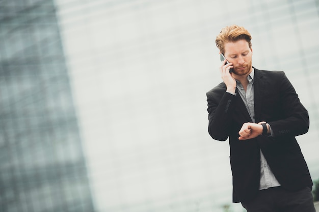 Young businessman with mobile phone on the street