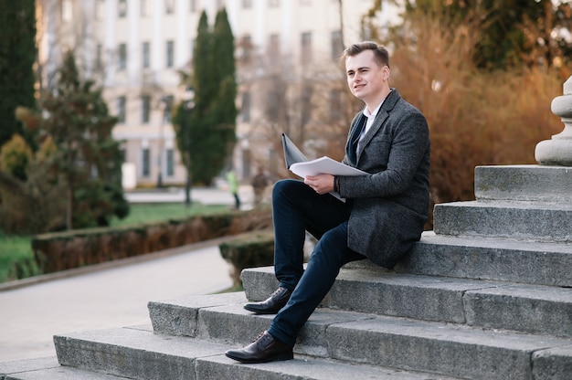 Young businessman with paperwork on the stairs