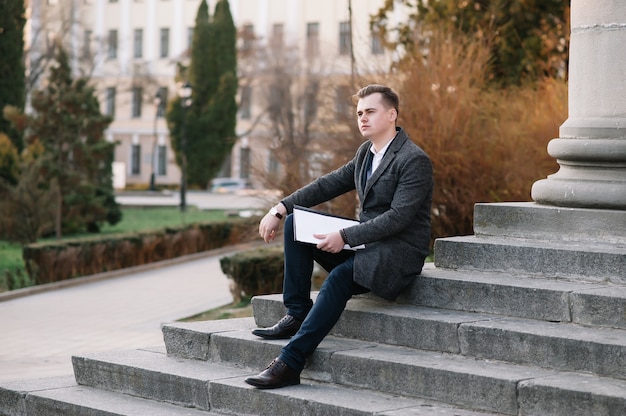 Young businessman with paperwork on the stairs