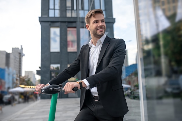 Young businessman with the scooter in the street