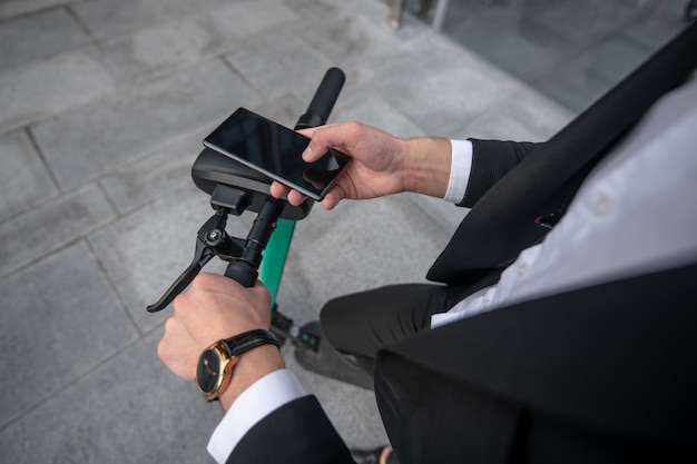 Young businessman with the scooter in the street