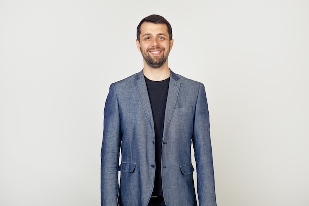 Young businessman with a smile, a man with a beard in a jacket, with a happy and cool smile on his face.